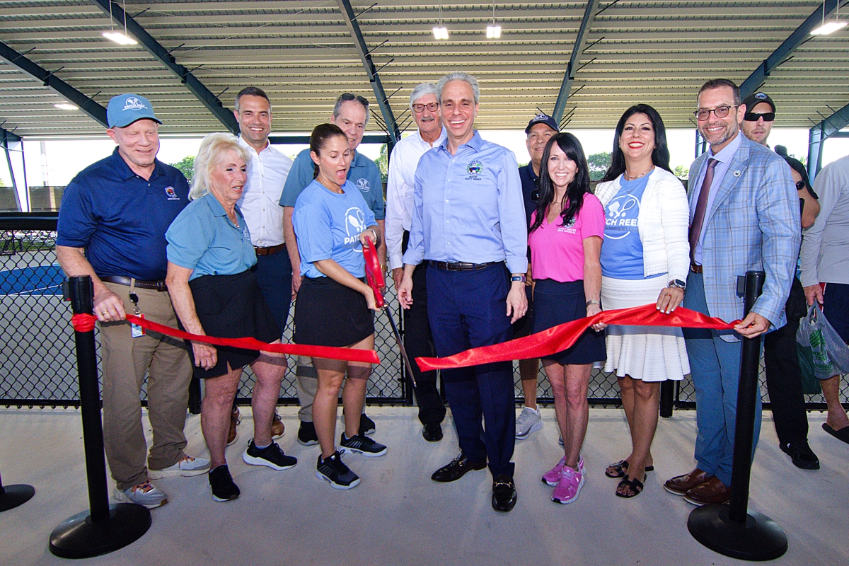 Surrounded by District Commissioners and other dignitaries, District chair Erin Wright cuts the ribbon