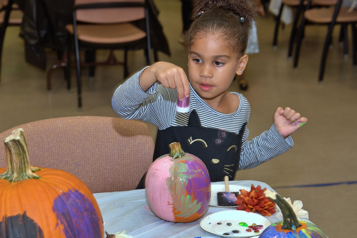 Girl Sprinkle Glitter On Pumpkin