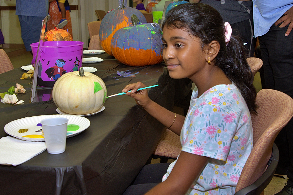 Girl paint white pumpkin