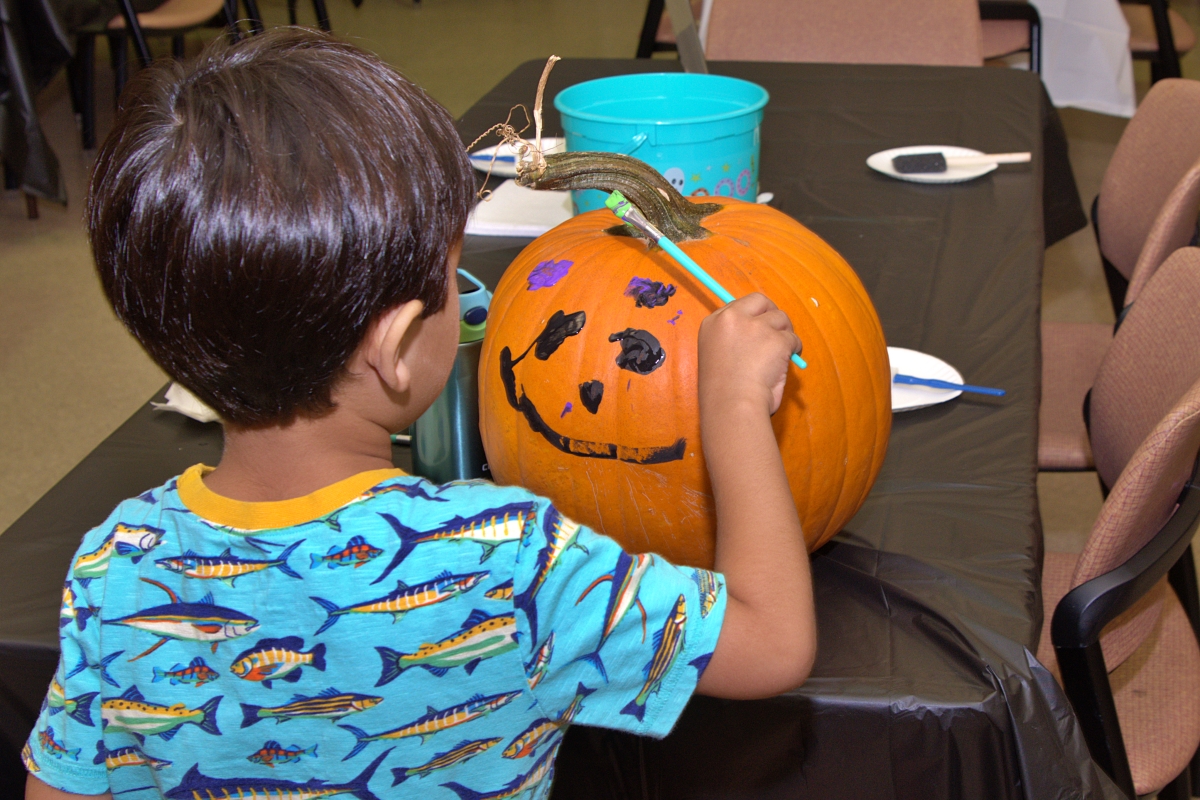 Boy painting his pumpkin