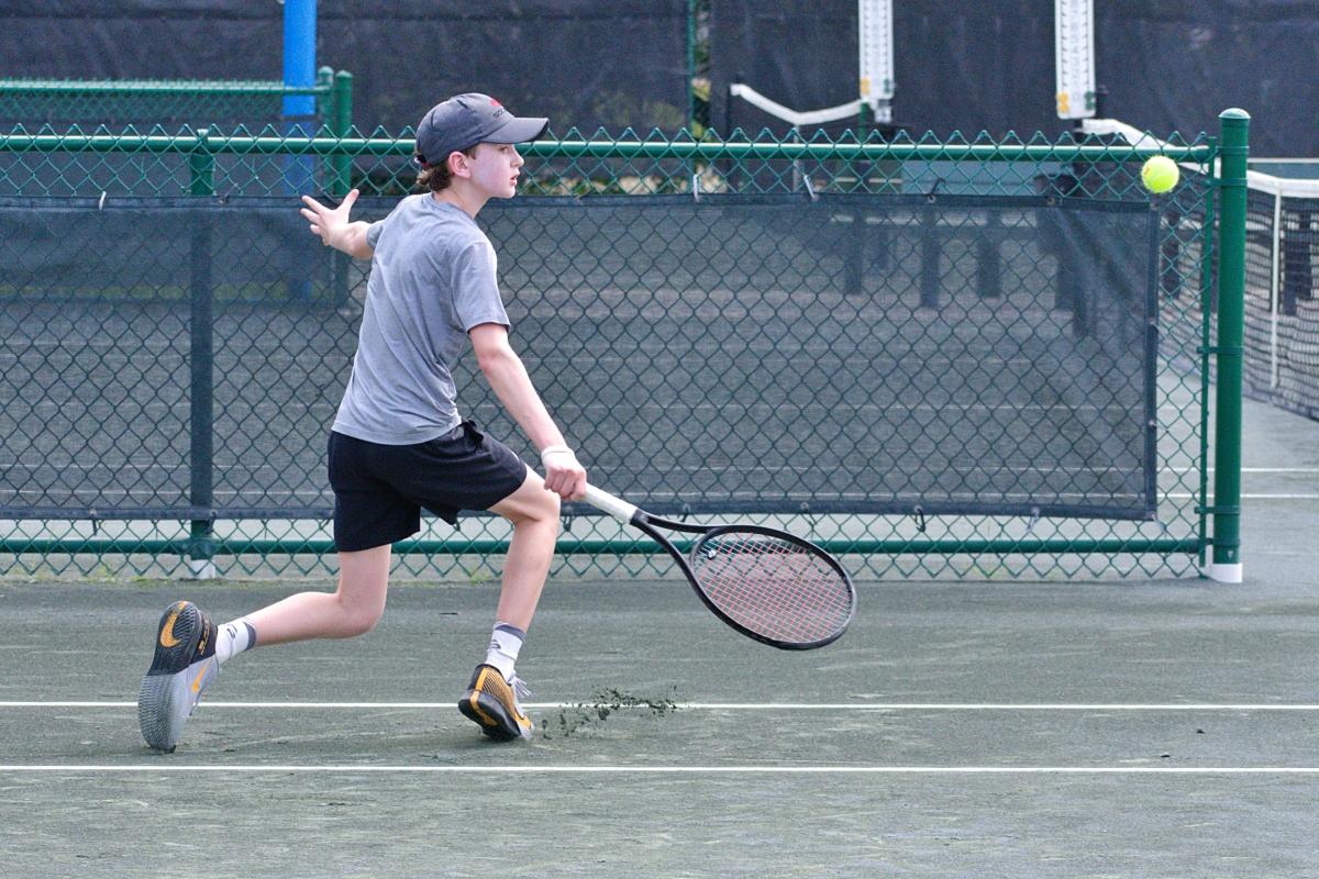 Junior boy digs out a shot