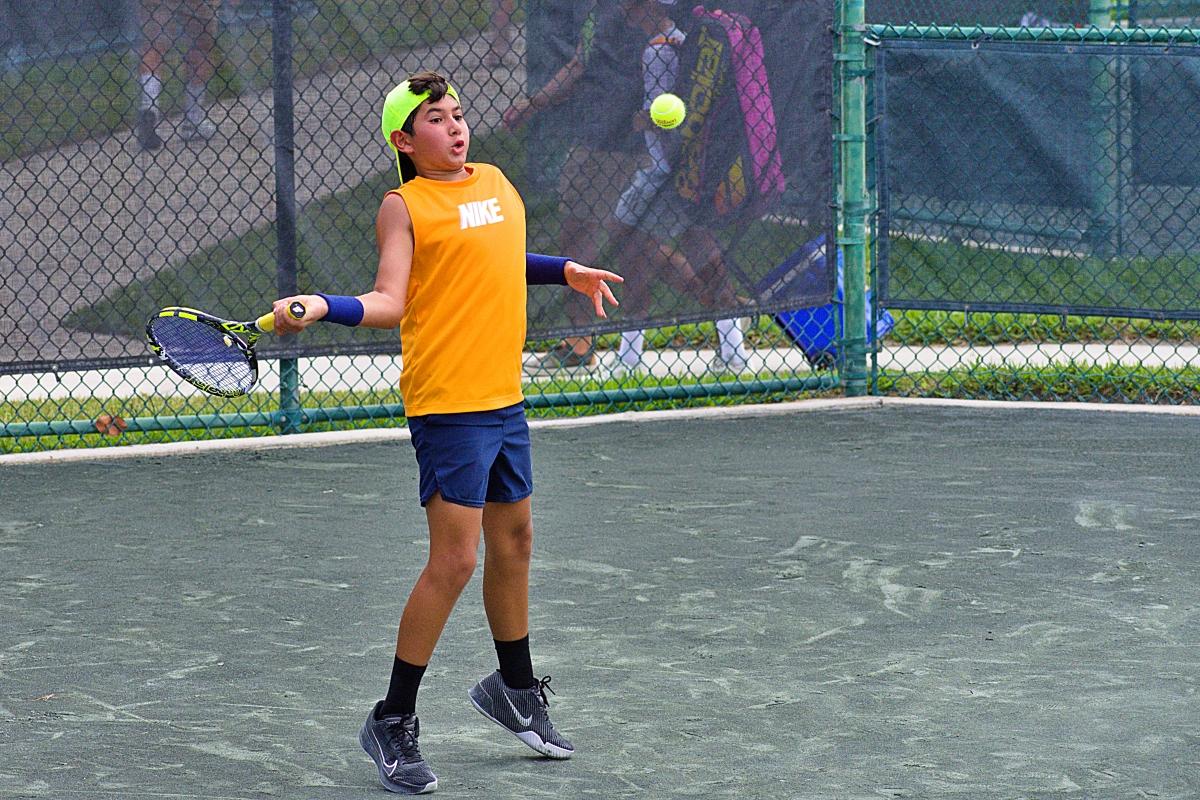 Junior boy gets on his toes for a forehand