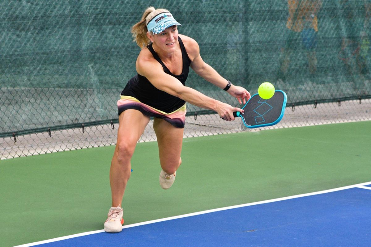 A woman lunging for a shot at Pickleboo