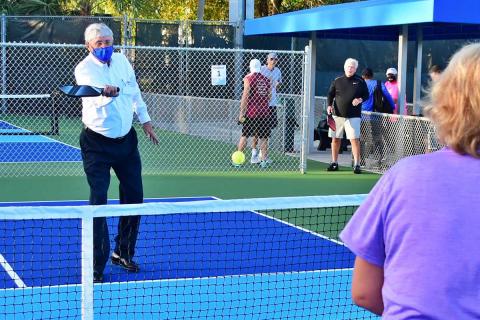 District Commissioner Bob Rollins helps open the Patch Reef Park pickleball courts.