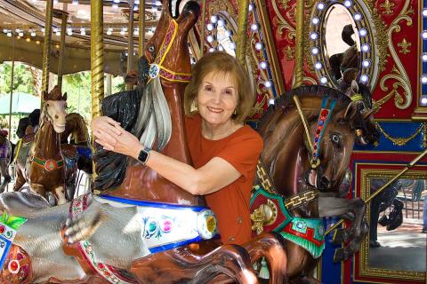 Madlane Bentivegna hugs a carousel horse at Sugar Sand Park