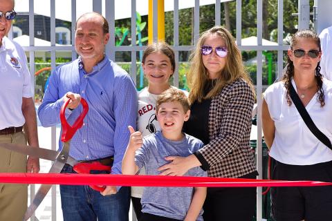 Jordan Ogman gives the thumbs up moments before father David cuts the ribbon opening the newly renovated, all-inclusive playground at Patch Reef Park. 